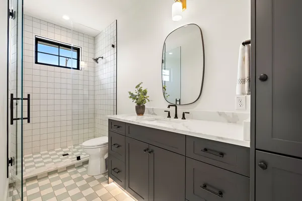 a bathroom with a granite countertop toilet a sink and a mirror