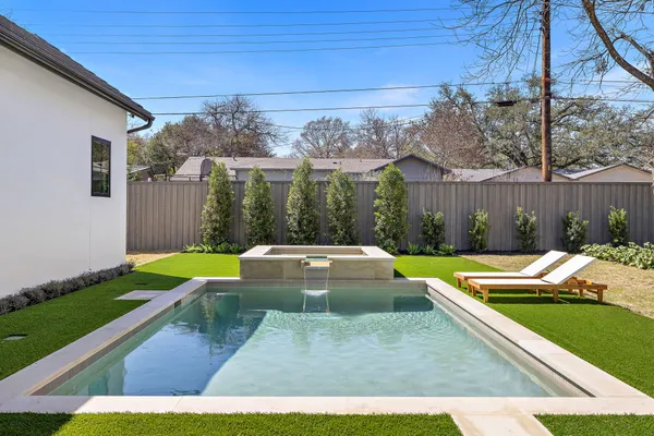 a view of house with swimming pool and furniture