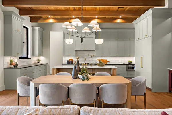 a dining room with furniture a chandelier and kitchen view