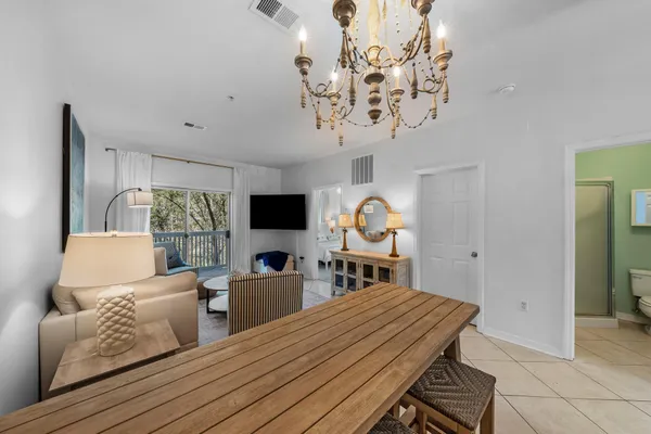 a living room with furniture a chandelier and a flat screen tv