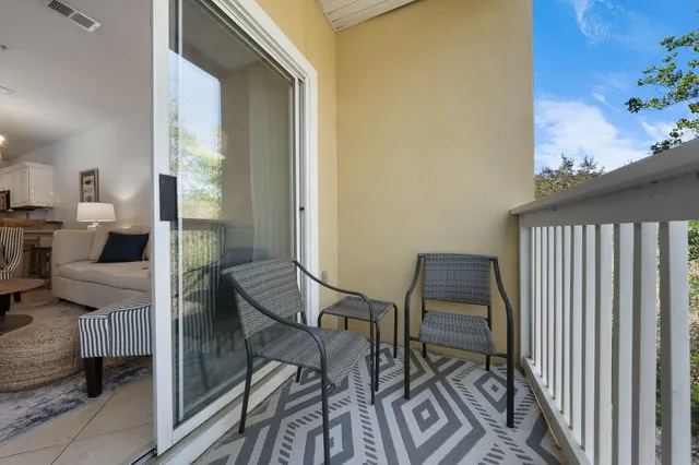 a view of a balcony with chairs and a potted plant