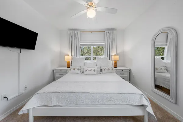 a bedroom with a bed and a flat tv screen on the dresser