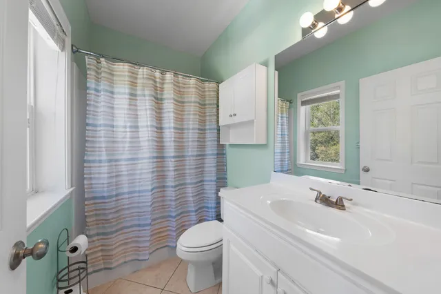 a bathroom with a sink a toilet and shower curtain