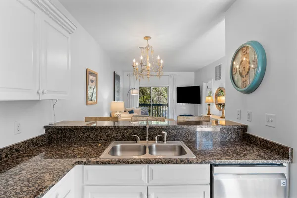 a kitchen with granite countertop a sink and a stove top oven