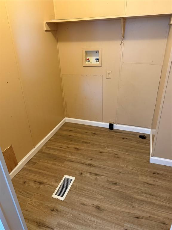 143 Summit Ridge Lane Springtown, TX 76082 - Photo 12 of 19 Wood-finish flooring with white trim, laundry hookups, and a wall shelf