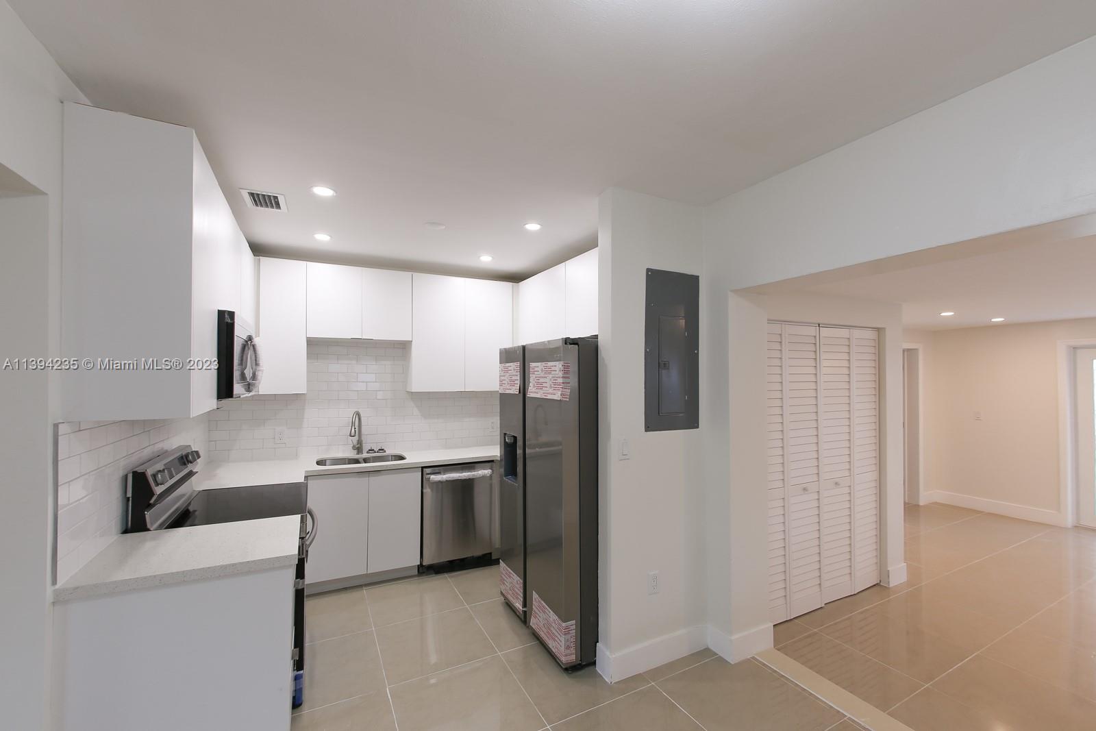 5410 Southwest 4th Street Miami, FL 33134 - Photo 7 of 23 a kitchen with stainless steel appliances granite countertop a refrigerator sink and cabinets