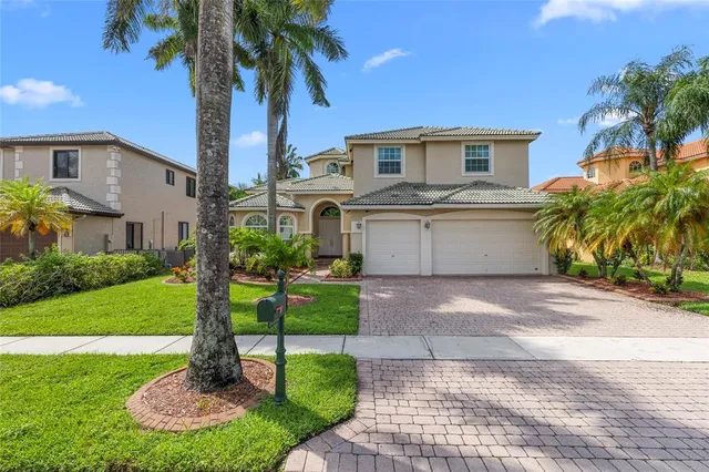 a front view of a house with a yard and palm tree