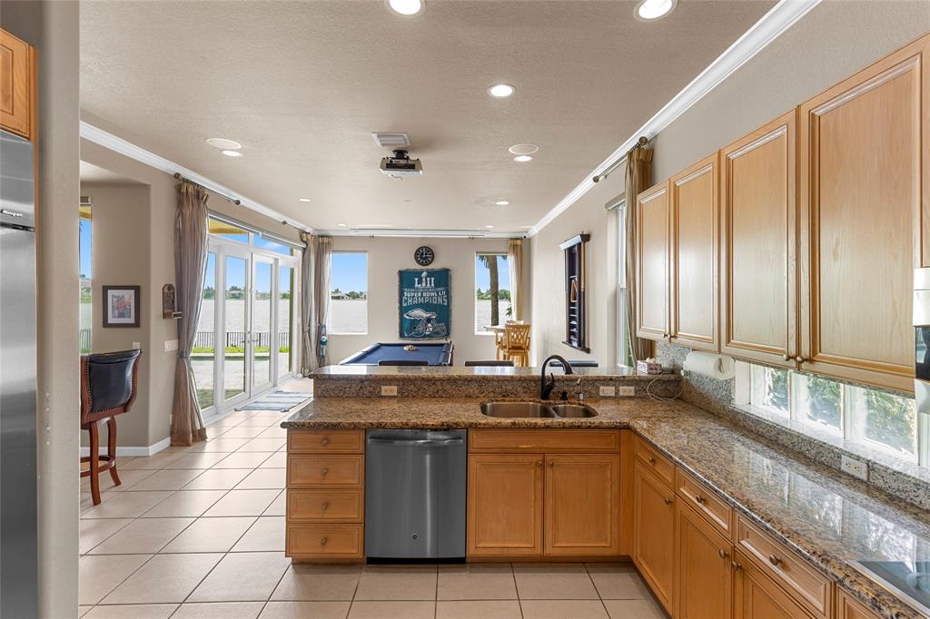 18932 Southwest 33rd Court Miramar, FL 33029 - Photo 9 of 97 a large kitchen with granite countertop a sink and a stove