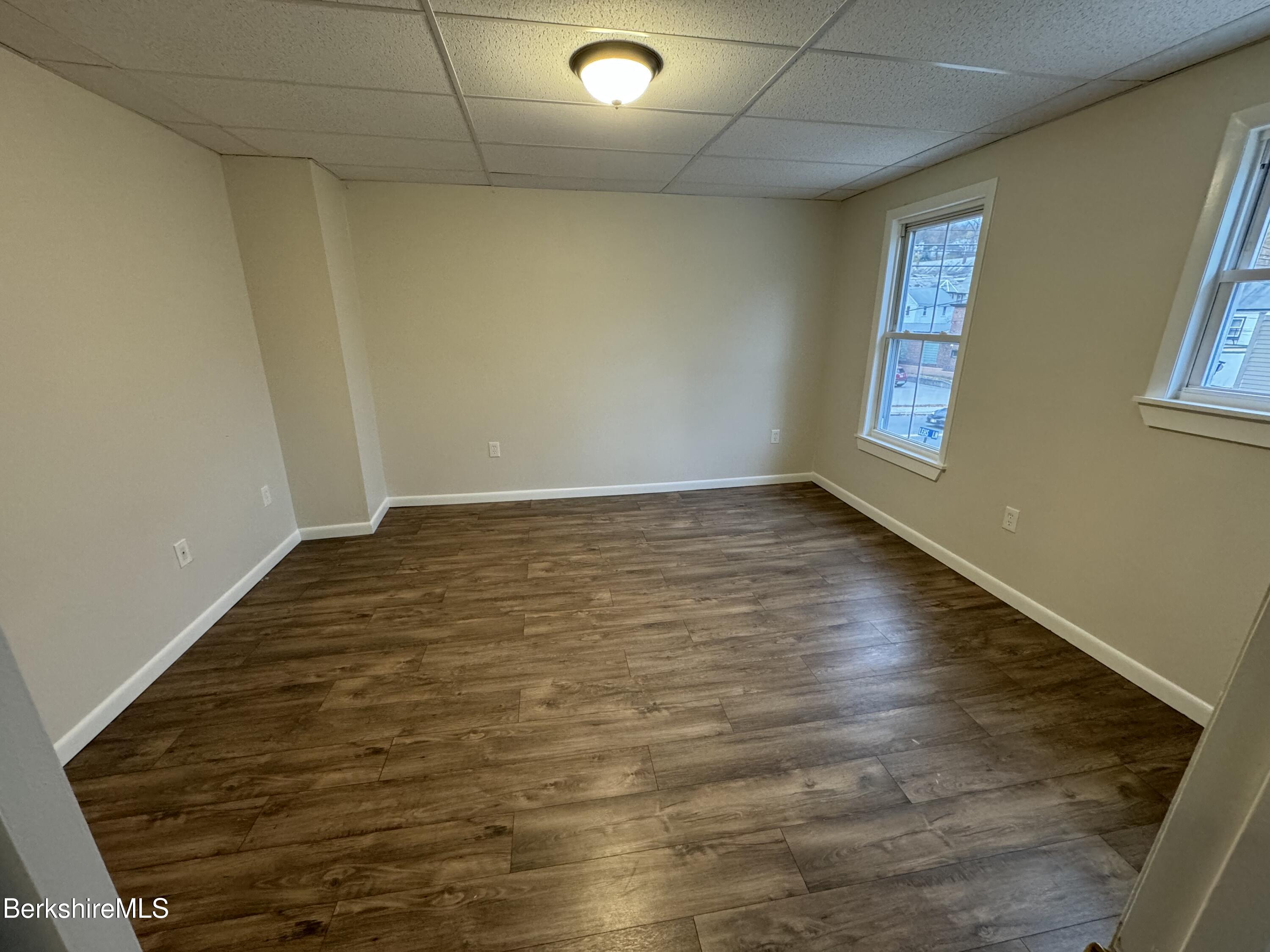 84 Summer Street, Unit B Adams, MA 01220 - Photo 2 of 8 an empty room with wooden floor and windows