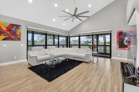 a living room with furniture kitchen and a large window