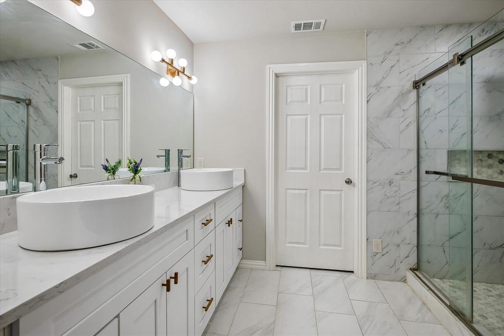 2001 Pebblebrook Trail Irving, TX 75060 - Photo 17 of 40 The Primary Bathroom, Ensuite, on the 1st level has been completely remodeled and has heated floors, dual sinks, an oversized shower and a huge walk-in closet.