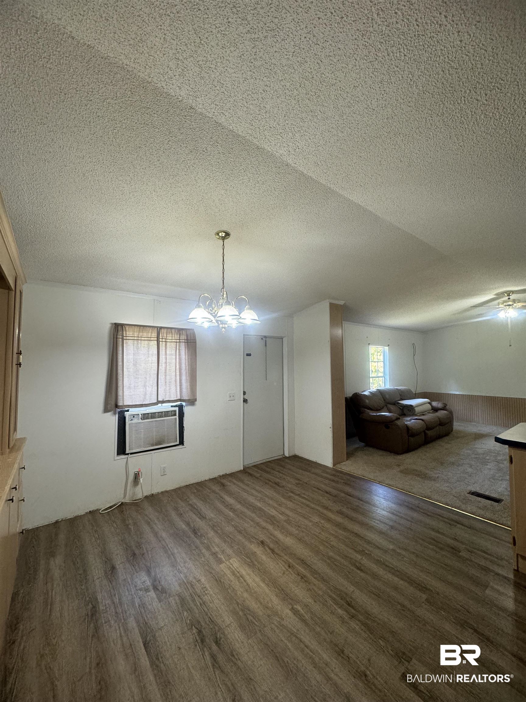 1067 County Road 7 Range, AL 36473 - Photo 5 of 30 Interior space featuring dark wood-type flooring, cooling unit, and a textured ceiling