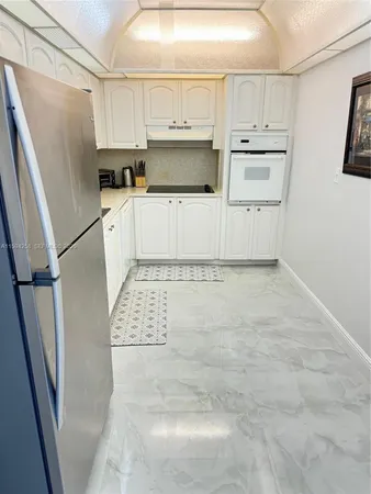 a kitchen with white cabinets and white appliances