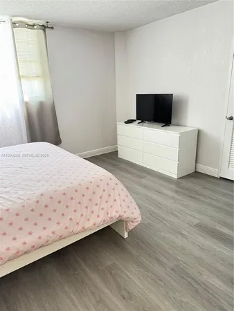 a bedroom with a bed and flat screen tv