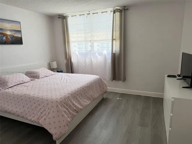 a large bed sitting in a bathroom next to a window