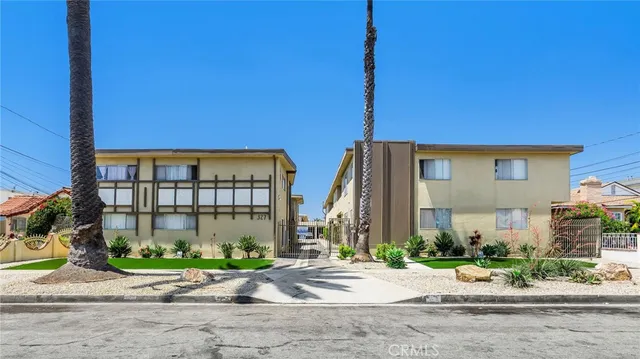 a front view of multiple houses with a yard
