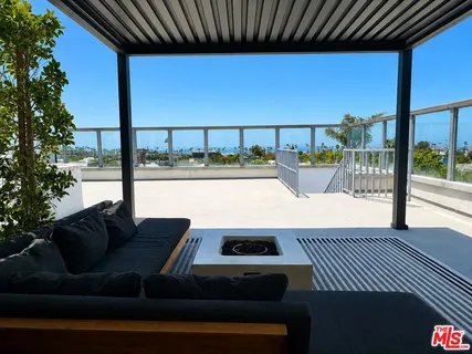 a view of a balcony with chairs and iron fence