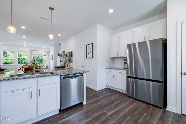 a kitchen with a refrigerator sink and cabinets