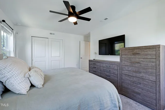 a bedroom with a bed and a flat screen tv