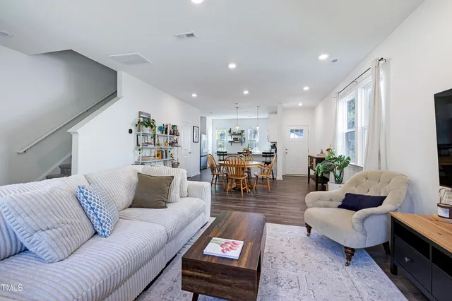 a living room with furniture and wooden floor