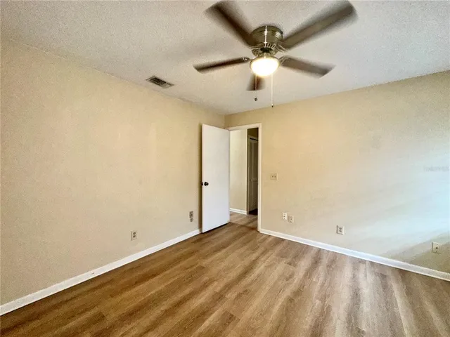 an empty room with a ceiling fan and carpet