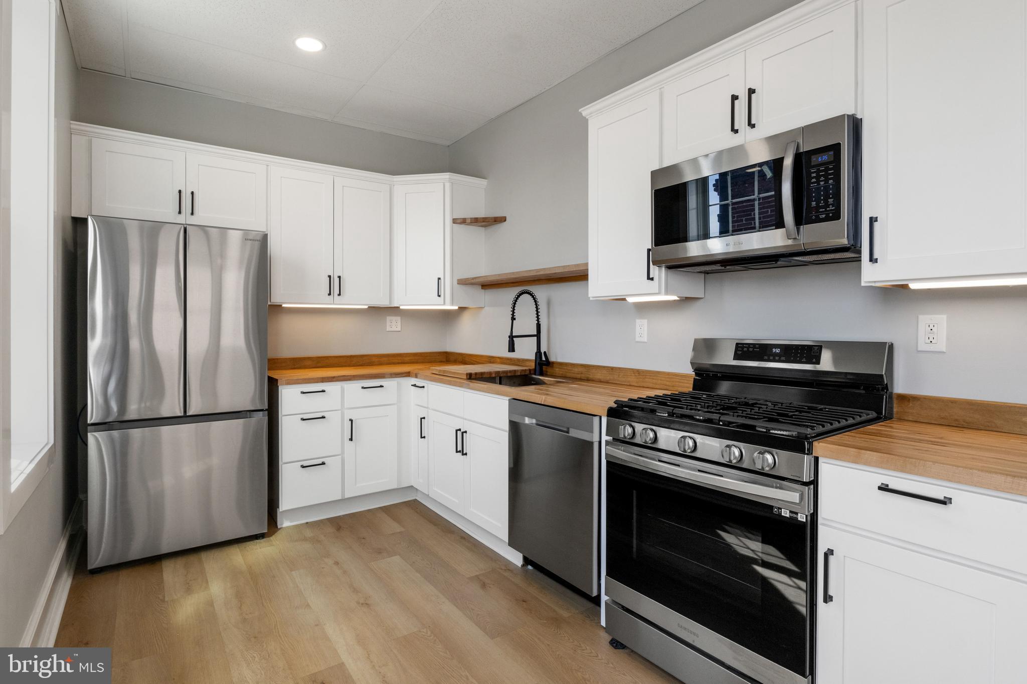 125 North George Street York, PA 17401 - Photo 18 of 56 a kitchen with stainless steel appliances a stove a microwave sink and refrigerator