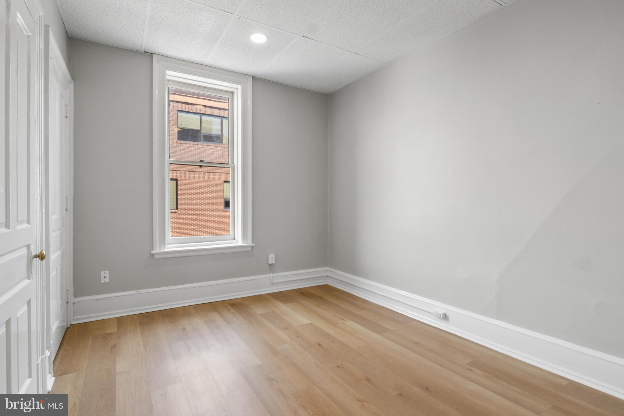 125 North George Street York, PA 17401 - Photo 23 of 56 an empty room with wooden floor and window