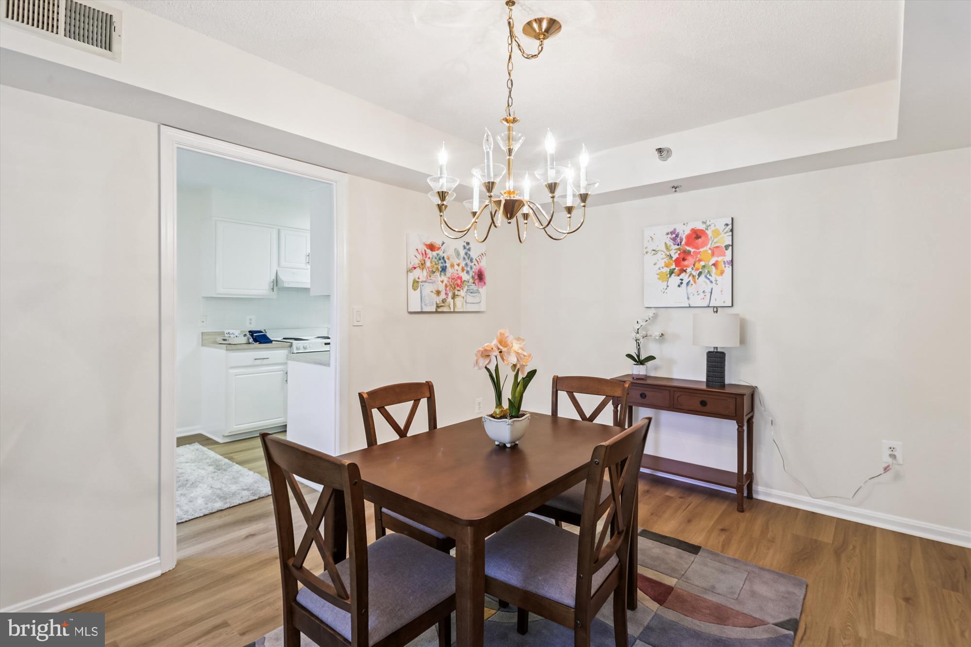 14801 Pennfield Circle, Unit 210 Silver Spring, MD 20906 - Photo 14 of 39 a view of a dining room with furniture wooden floor and a chandelier