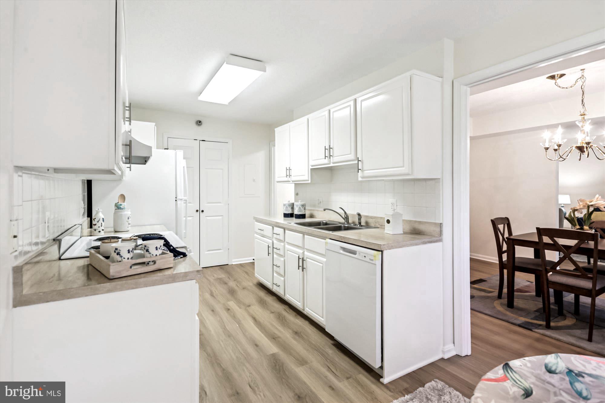 14801 Pennfield Circle, Unit 210 Silver Spring, MD 20906 - Photo 16 of 39 a kitchen with a sink stove and white cabinets