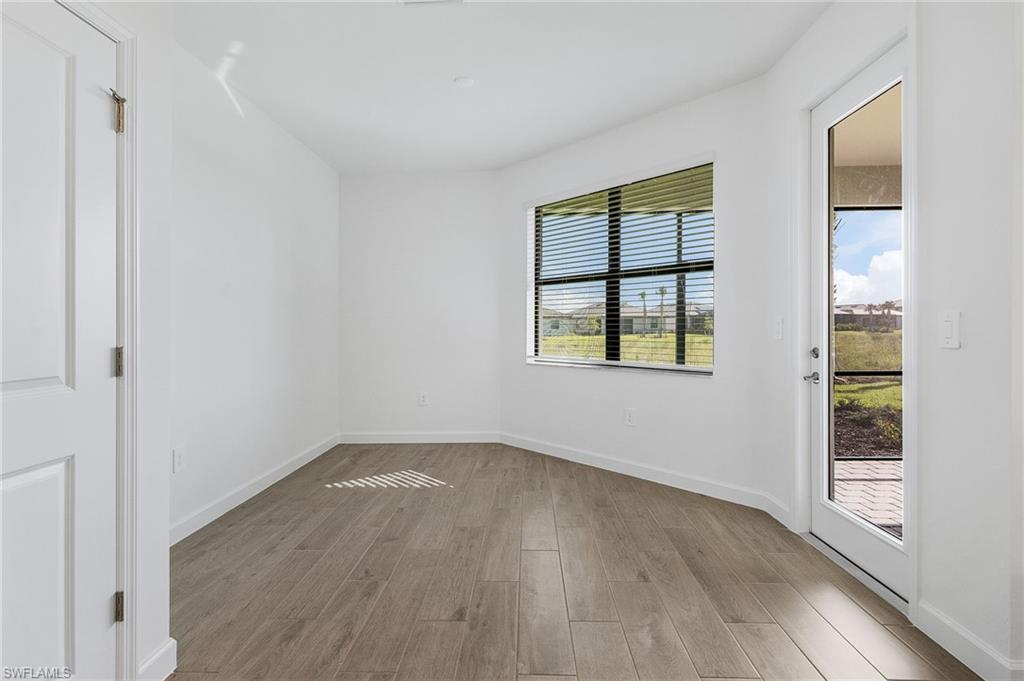 20662 Greenwich Place Estero, FL 33928 - Photo 12 of 26 an empty room with wooden floor and windows