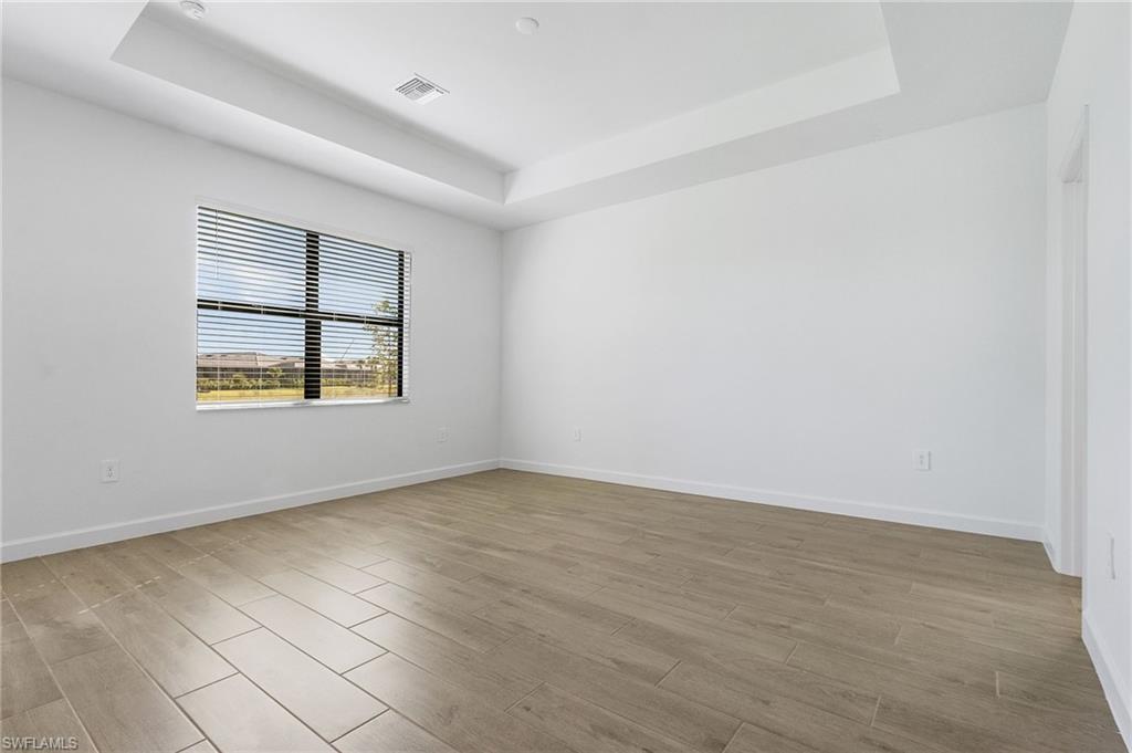 20662 Greenwich Place Estero, FL 33928 - Photo 18 of 26 an empty room with wooden floor and windows