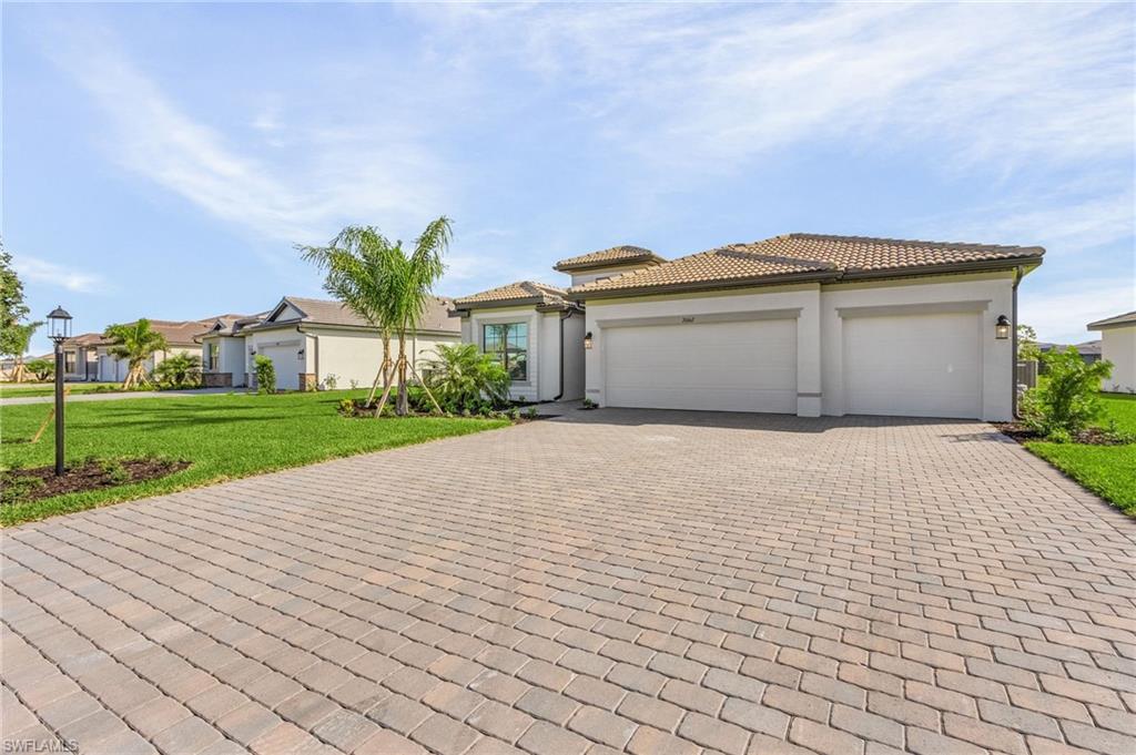 20662 Greenwich Place Estero, FL 33928 - Photo 2 of 26 a front view of a house with a yard and garage