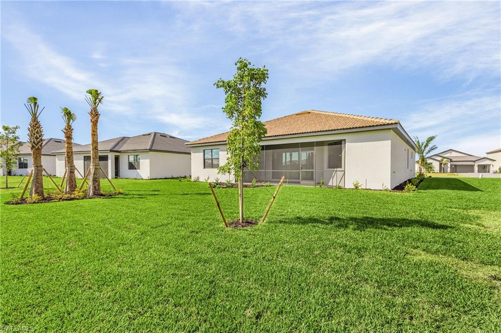 20662 Greenwich Place Estero, FL 33928 - Photo 22 of 26 a view of a house with a yard and a garden