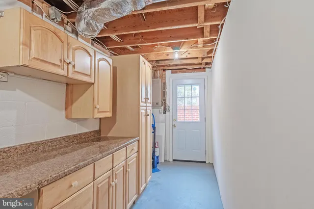 a bathroom with a granite countertop sink and washing machine