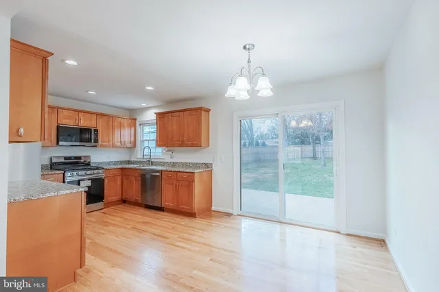 a open kitchen with stainless steel appliances granite countertop a stove top oven a sink dishwasher a kitchen island with cabinets and wooden floor