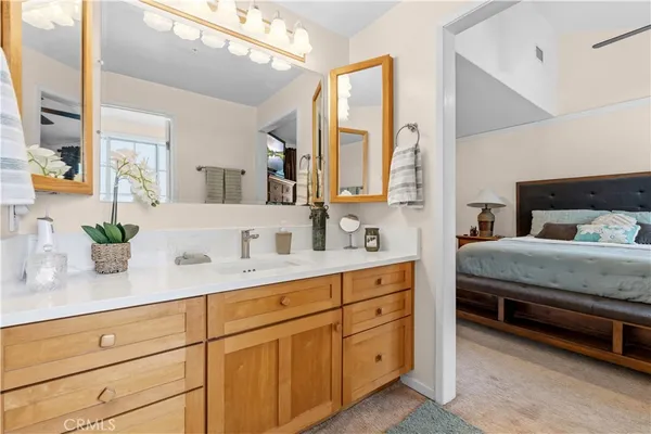 a bedroom with a bed and a potted plant on the dresser