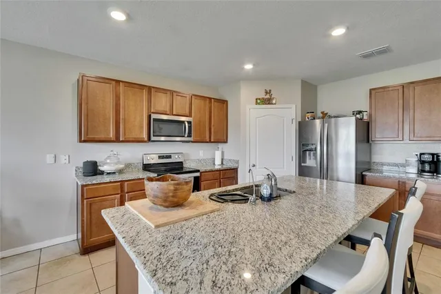 a kitchen with stainless steel appliances granite countertop a sink stove and refrigerator