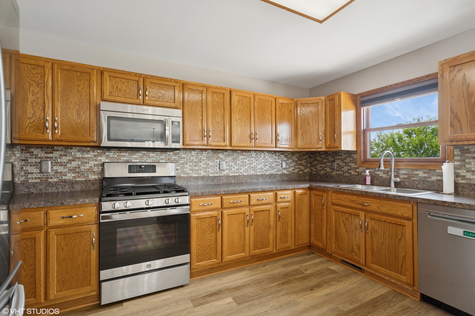 2033 Willow Brook Drive Bourbonnais, IL 60914 - Photo 4 of 24 a kitchen with stainless steel appliances a stove a sink and a microwave