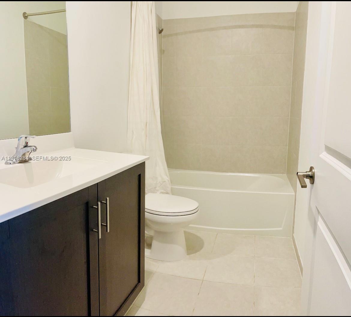 2624 Southeast 11th Court, Unit 2624 Homestead, FL 33035 - Photo 11 of 19 a bathroom with a sink a toilet and shower