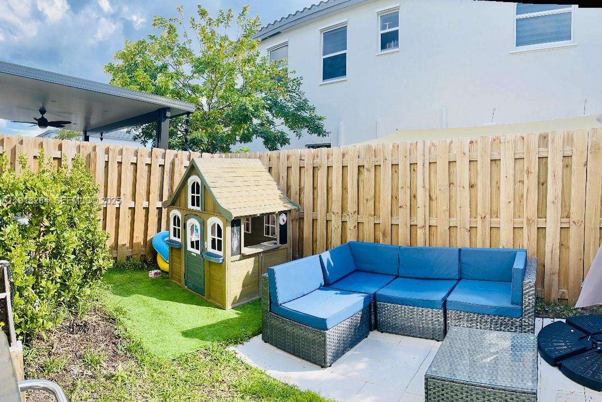 2624 Southeast 11th Court, Unit 2624 Homestead, FL 33035 - Photo 13 of 19 a view of a couches in the patio with a small yard