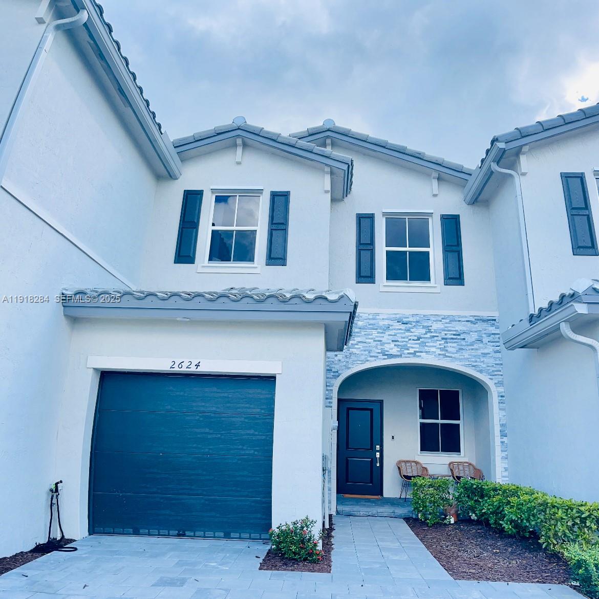 2624 Southeast 11th Court, Unit 2624 Homestead, FL 33035 - Photo 5 of 19 a front view of a house with garage