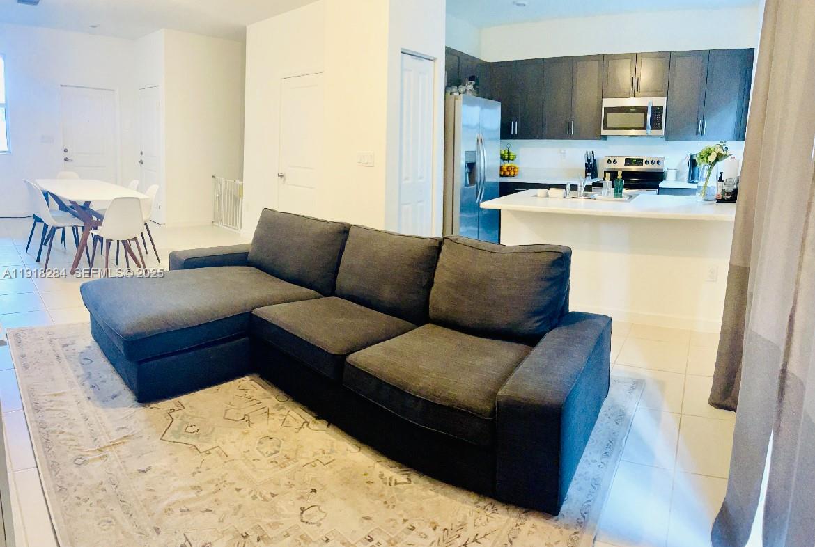 2624 Southeast 11th Court, Unit 2624 Homestead, FL 33035 - Photo 10 of 19 a living room with stainless steel appliances kitchen island granite countertop a refrigerator and a sink