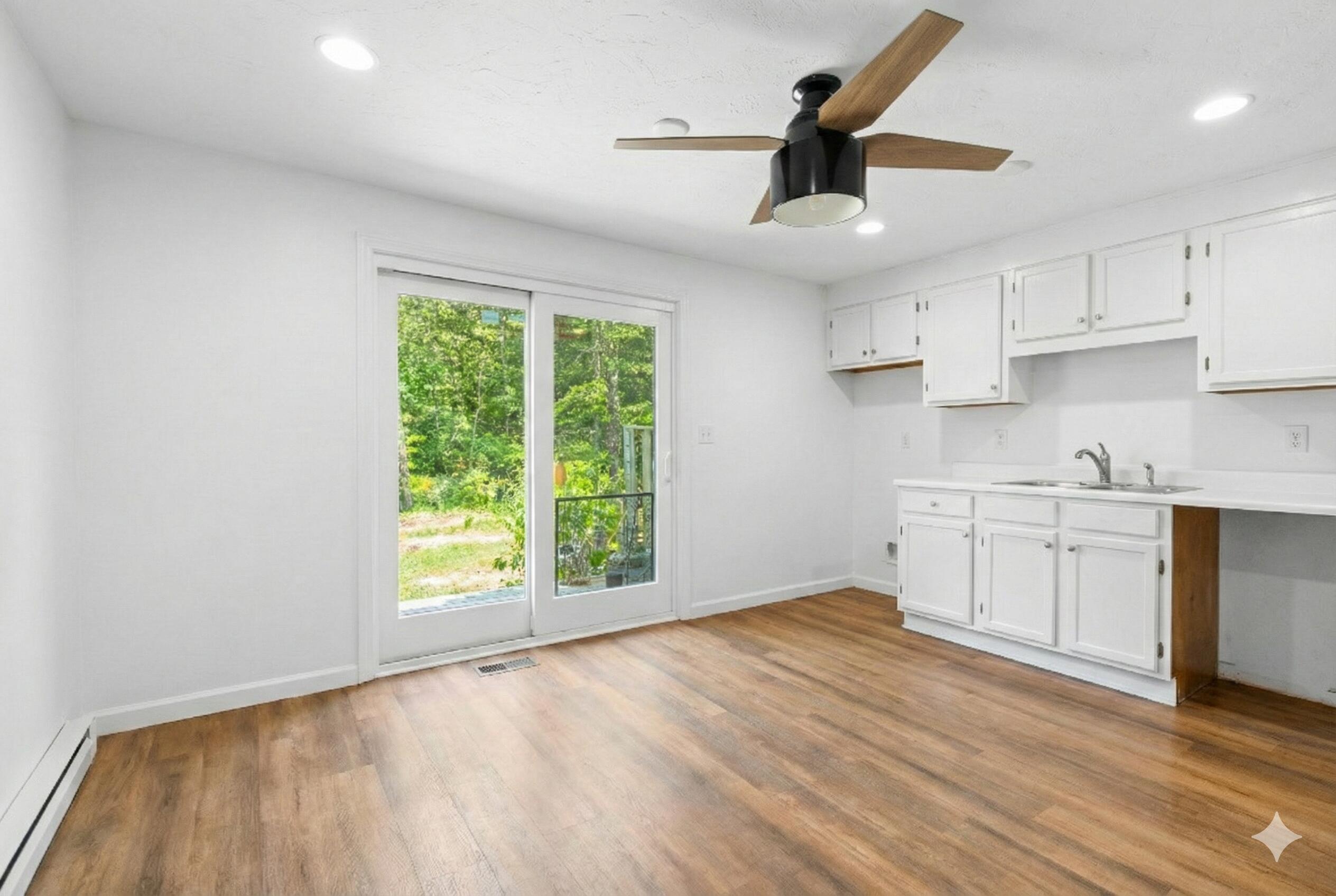 300 Falmouth Road, Unit 20C Mashpee, MA 02649 - Photo 7 of 38 a kitchen with stainless steel appliances granite countertop a stove a sink and white cabinets with wooden floor next to windows
