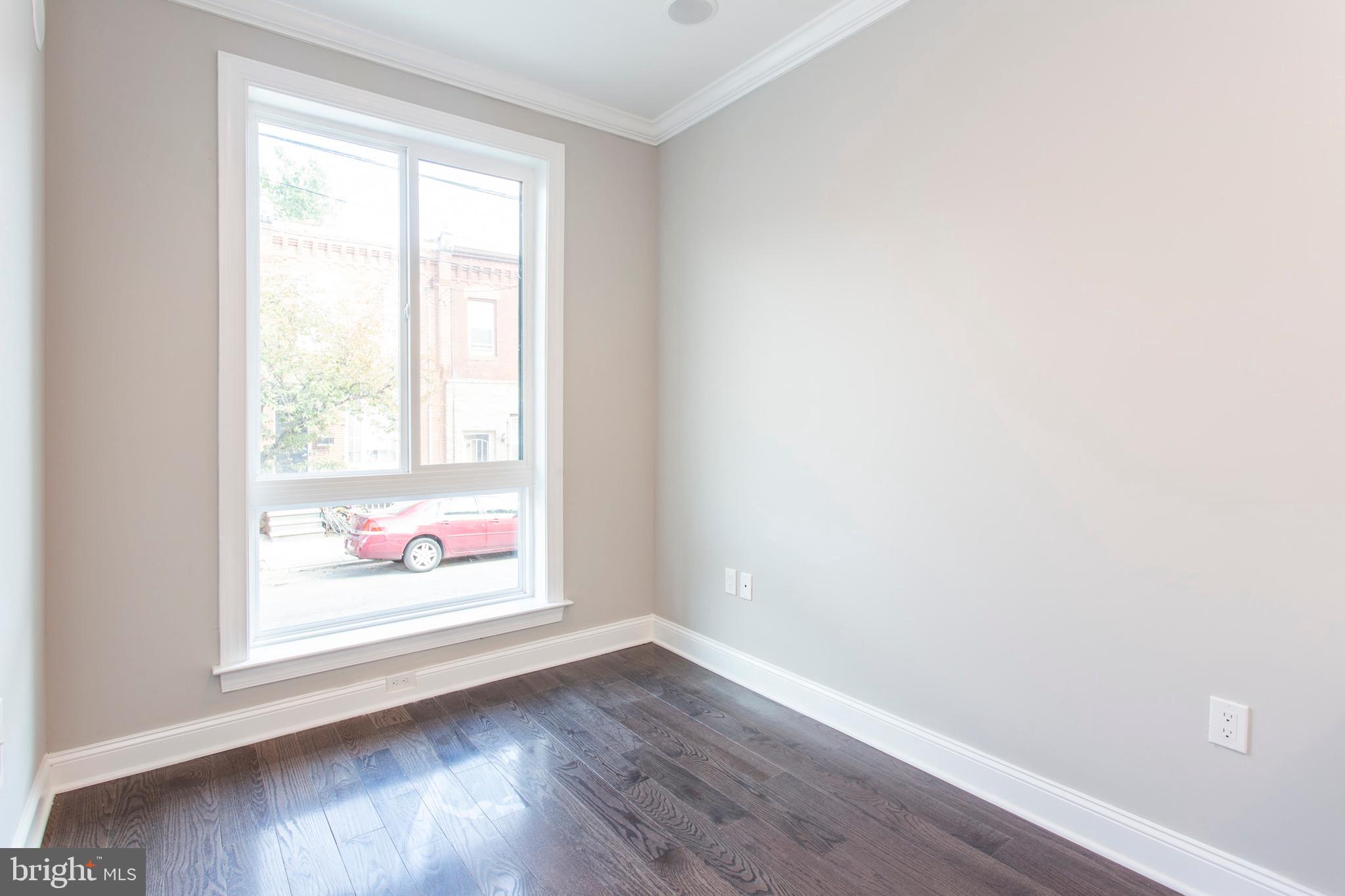 an empty room with wooden floor and window