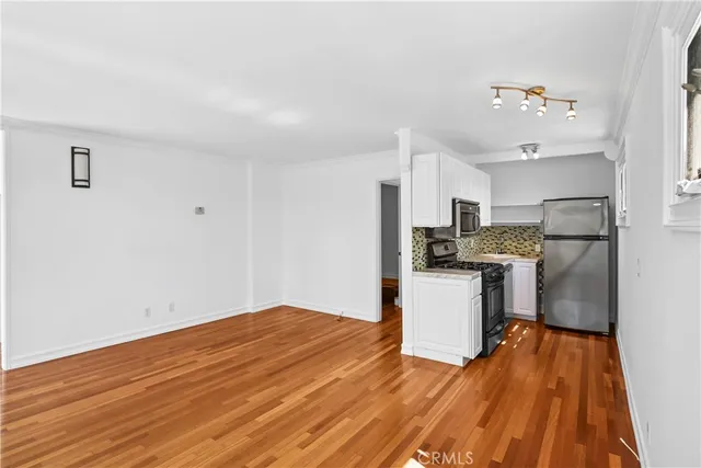 a view of empty room with wooden floor and window