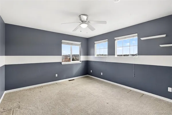 a view of an empty room with window and cabinet