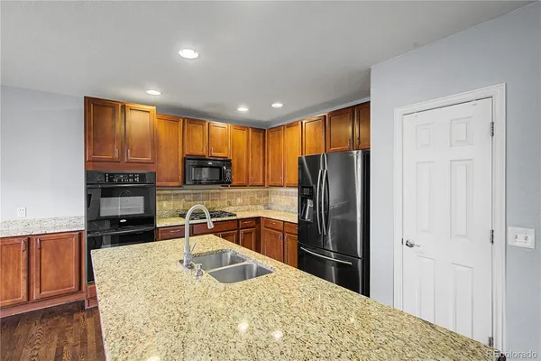 a kitchen with stainless steel appliances granite countertop a refrigerator stove top oven a sink and dishwasher