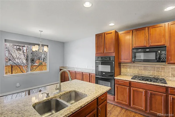 a kitchen that has a sink cabinets counter space appliances and a window
