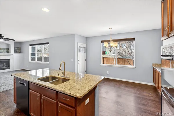 a kitchen with stainless steel appliances granite countertop a sink dishwasher and microwave with wooden floor