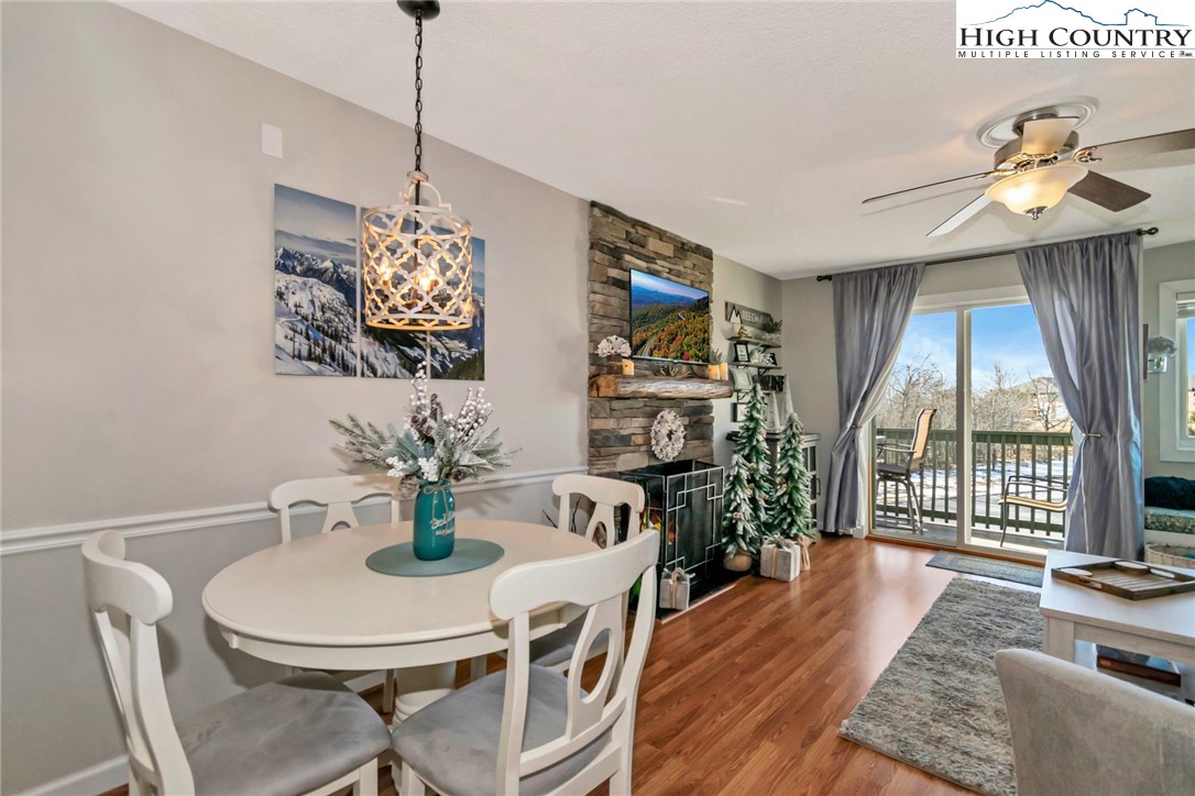 301 Pinnacle Inn Road, Unit 1215 Banner Elk, NC 28604 - Photo 12 of 47 a view of a dining room with furniture a chandelier and wooden floor